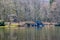 Lake with slight reflection on the water surface with bare trees and a stone fountain in the background