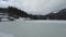 Lake Spitzingsee in winter covered with snow and ice in freezing cloudy weather in Bavaria, Germany. A mountain lake in