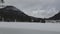 Lake Spitzingsee in winter covered with snow and ice in freezing cloudy weather in Bavaria, Germany. A mountain lake in