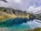 Lake with submerged tree trunks. Waterfall in rocky mountains. Gray clouds in the sky and blue sea, the beauty of the bay, the