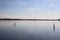 Lake at sunset with the sky casted in the water and a sailboat in the distance