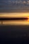 Lake at sunset with the sky casted in the water seen from the shore