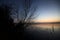 Lake at sunset with trees and the sky casted in the water