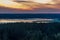 A lake surrounded by forest expanses after sunset