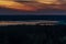 A lake surrounded by forest expanses after sunset