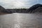 Lake surrounded by gray clay hills against the evening sky. Ural refractory clay quarries