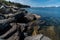 Lake Tahoe Blue lake side water ripples and rocky coastline with Snow capped mountains