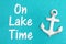 On lake time message on weathered anchor on a turquoise glitter paper