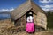 lake titicaca floating islands indigenous woman of the uro culture in long colored skirts with straw hats and braids standing with