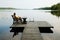 Lake with wooden platform and woman resting.