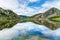 Lakes of Covadonga, Lake Enol, with the mountains and clouds reflected on the water, on a day with a cloudy sky and no wind