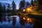 lakeside cabin with warm lights on during twilight