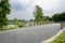 Lakeside fenced bridge with tarred roadway in cloudy summer aft