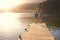 Lakeside love. Rearview shot of an affectionate young couple standing on a dock at sunset.