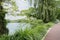 Lakeside path in grass and trees on cloudy summer day