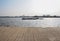 Lakeside planked path with boats on water in background