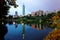 Lakeside scenery of Taipei 101 Tower among skyscrapers in Xinyi District Downtown at dusk with view of reflections on the pond