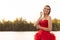 Lakeside Serenity: Graceful Woman in a Flowing Red Gown