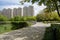 Lakeside shady path before multi-story apartments in sunny summer