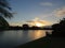 Lakeside view of palm trees and orange fiery sunset