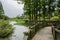 Lakeside wooden footbridge to village in woods on sunny summer d