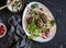 Lamb kebab on flatbread with lettuce, onions and pomegranate. On a dark background