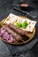 Lamb meat kofta kebab, onion and flat bread on plate. Black background. Top view