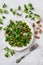 Lambs lettuce, radish and walnuts salad. Plate of cornsalad leaves, sliced radish and nut kernels on marble surface. Vitamin