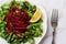Lambs lettuce with raw beet vitamin salad. Grated raw beet over fresh cornsalad leaves and lemon slice on a white plate over