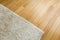 Laminate parquete floor. Light wooden texture. Beige soft carpet