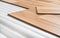 Laminated floor wood imitation tiles on white foam base layer. Closeup detail