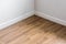 Laminated wood floor with white wall, room`s corner