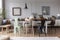 Lamp above wooden table with flowers in modern grey dining room interior with chairs. Real photo