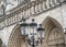 A lamp in the background of the main facade of Notre Dame de Paris