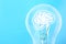 Lamp bulb with human brain inside on blue background, space for text. Idea generation