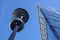 Lamp post in front of a Glass and concrete facade on a modern corporate skycraper building .