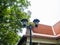 Lamp post in garden color black,Behind orange gable roof,Sky clean and clear,At Sri Nakhon Khuean Khan Park and Botanical Garden i