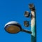 Lamp post with loudspeakers against blue sky