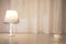 Lamp with wheat patterns and a coffee cup on desk against curtain background