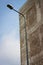 Lamppost with a concrete wall and sky on background