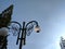 A lamppost with garden round lamps on sky background