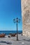 Lamppost by a historic sighting tower in Alghero