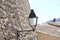 Lamppost lantern attached to medieval wall. Light off