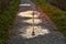 Lamppost reflected in three puddles