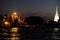 Lamps illuminate the embankment of the Chao Phraya River at night. Night city landscape