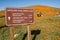 Lancaster, California - March 24, 2019: Sign in the Antelope Valley Poppy Reserve noting trail locations and distances. Tourists