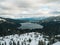 Land covered with snow overlooking the Donner Lake in Truckee, California under cloudy skies