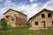 Land for development in rural neighborhood. Two new not finished brick family cottages houses divided with temporary fence on summ