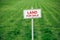 Land for sale sign against trimmed lawn background