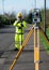 Land surveyor performing initial survey of the road levels and kerb lines before start of construction works using robotic